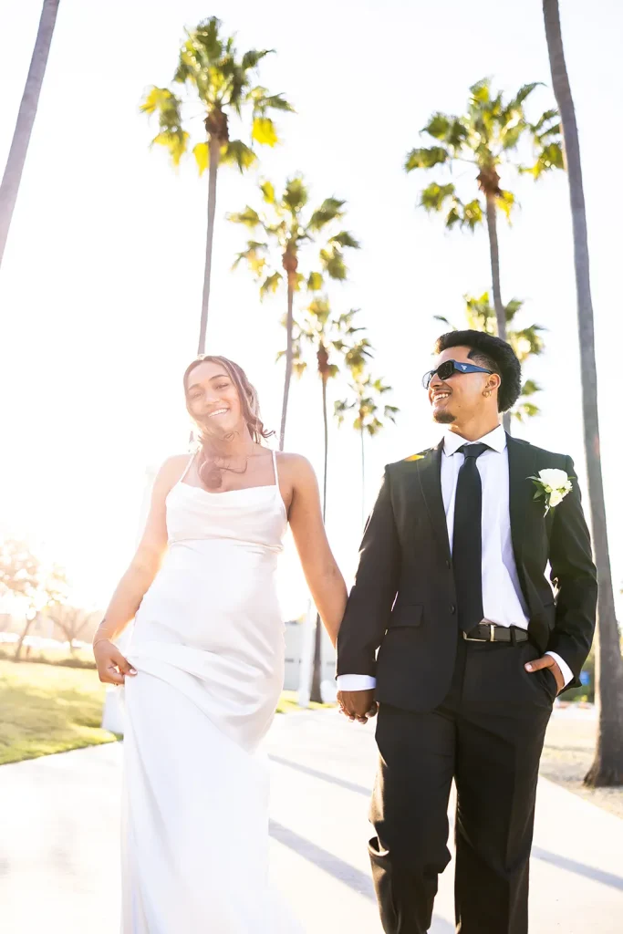 Wedding couple walking between palm tree path Shoreline Park Long Beach California NZ WEDDING STUDIO